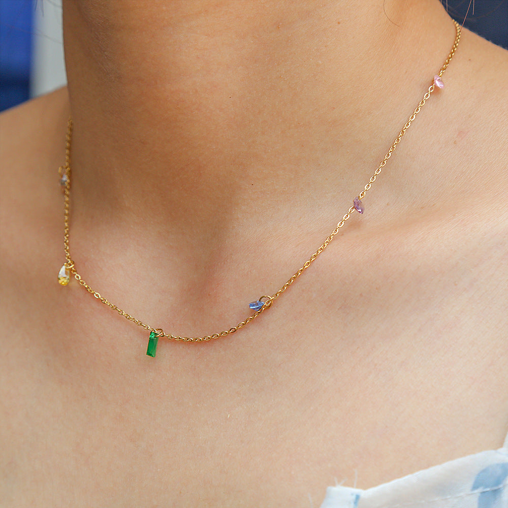 Gold necklace with colorful beads worn by a person