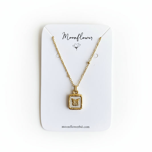 Gold necklace with a pendant on a Moonflower branded card.