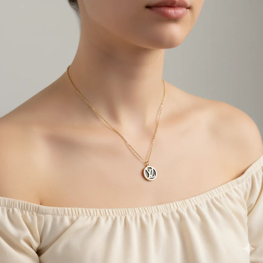 Necklace with a pendant worn by a person against a neutral background