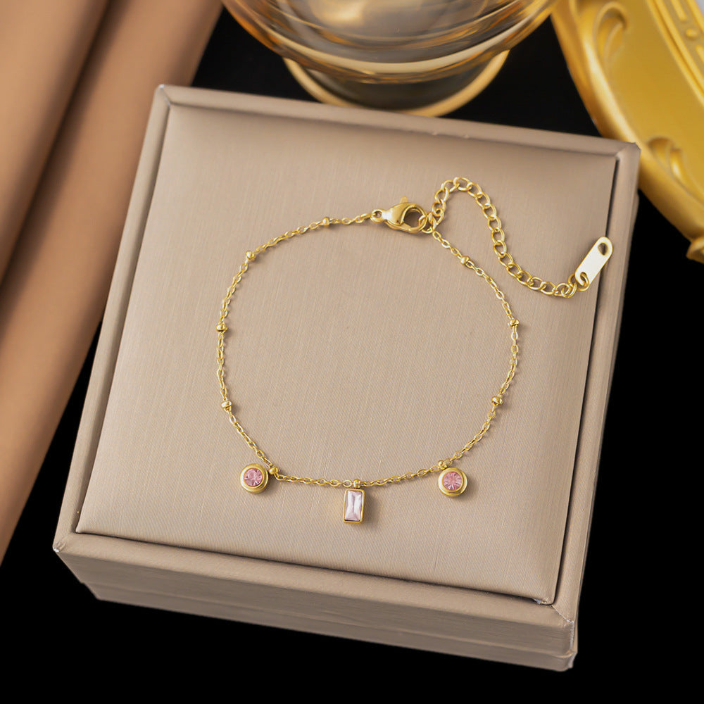 Gold bracelet with gemstones on a beige jewelry box