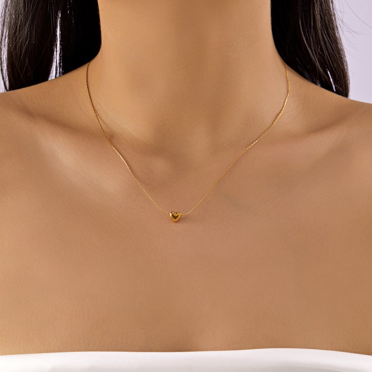 Gold necklace with a heart pendant on a mannequin