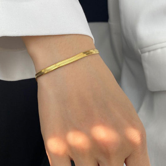 Gold bracelet on a wrist with a blurred background