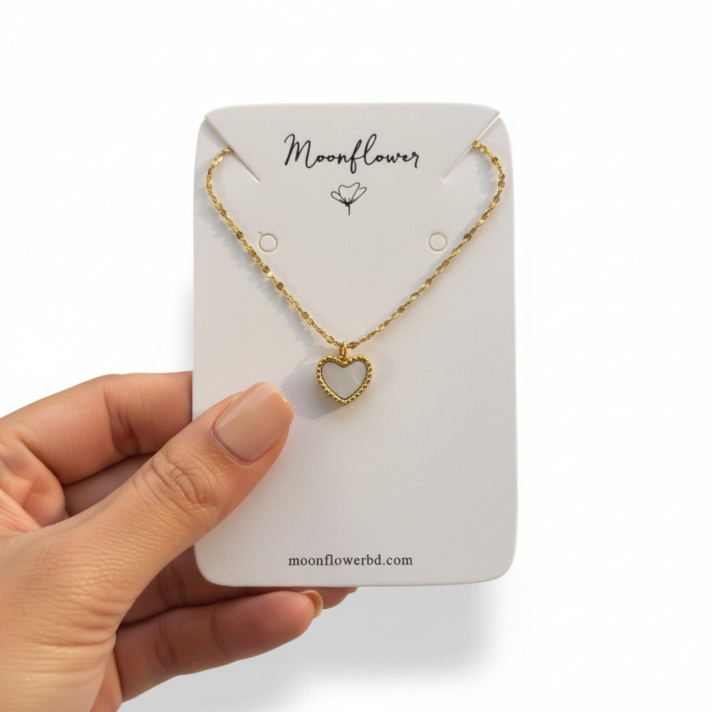Gold necklace with a heart pendant on a 'Moonflower' branded card.