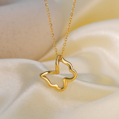 Gold necklace with a butterfly-shaped pendant on a soft beige fabric background