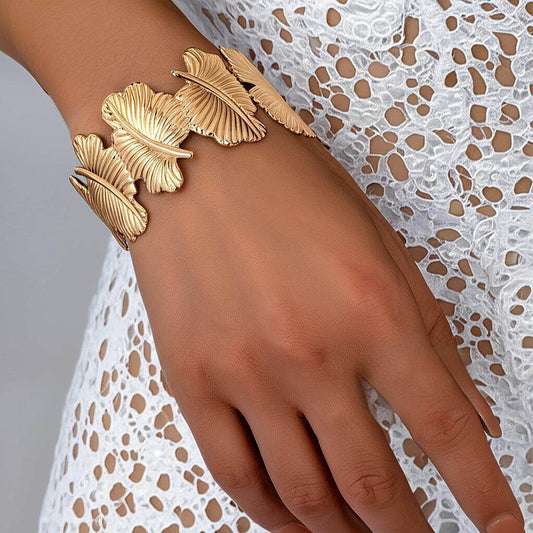 Gold leaf bracelet on a hand with a lace background
