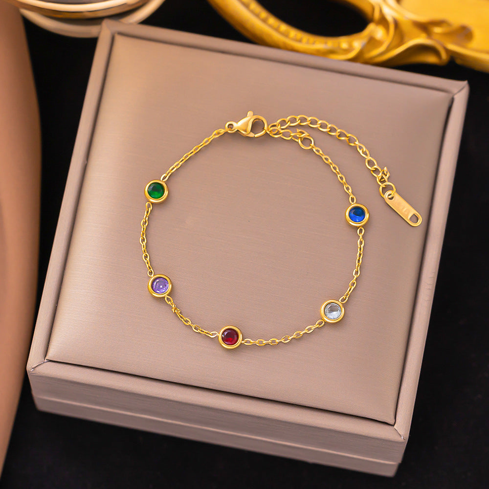Gold bracelet with colorful gemstones on a jewelry box