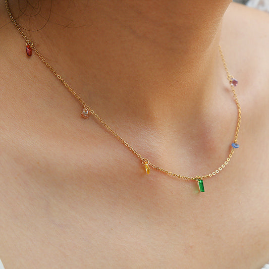 Gold necklace with colorful beads on a person's neck