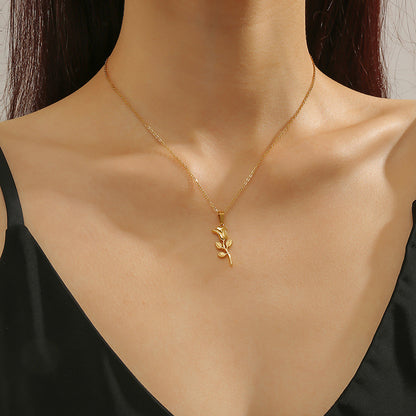 Gold necklace with a leaf pendant on a model wearing a black top.