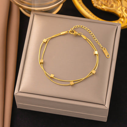 Gold bracelet on a gray jewelry box with a dark background
