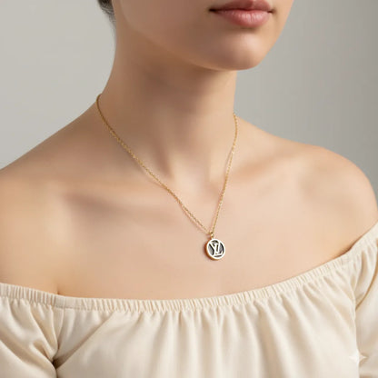 Necklace with a pendant worn by a person against a neutral background