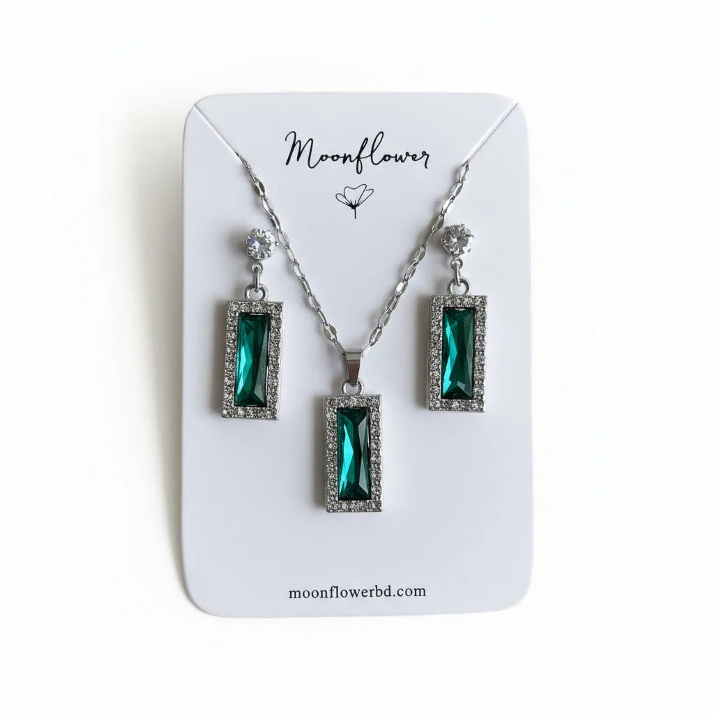 Jewelry set with green gemstones on a 'Moonflower' branded card.