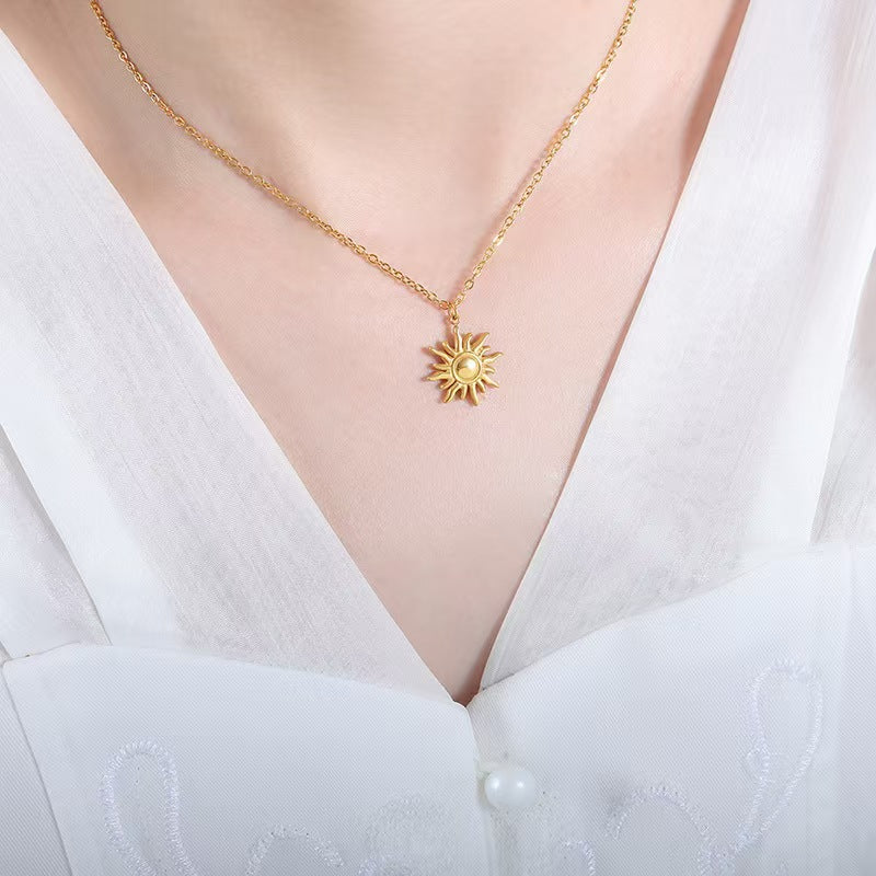 Gold necklace with a sun pendant on a white blouse