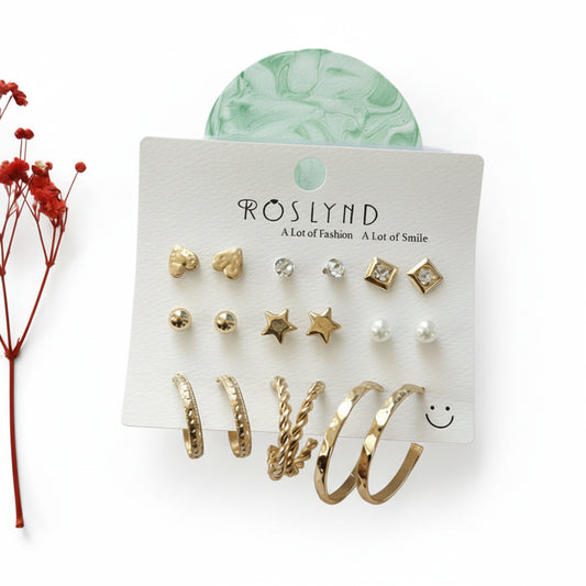 Set of gold earrings on a Roslynd branded card with a red flower and green decorative item in the background.