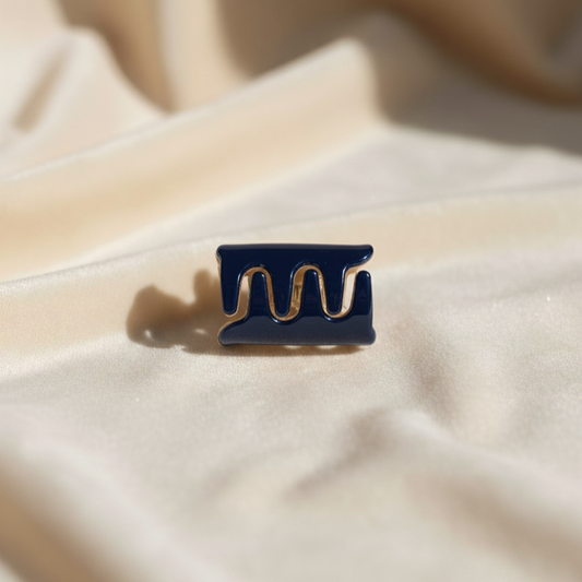 Navy blue hair clip on a beige fabric background